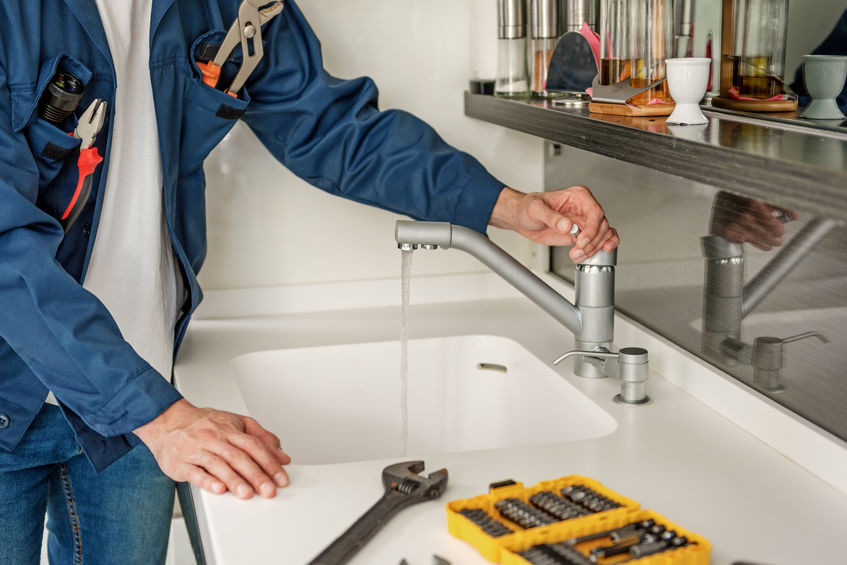 Repairman testing sink water leak
